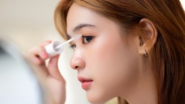 a woman putting clear mascara